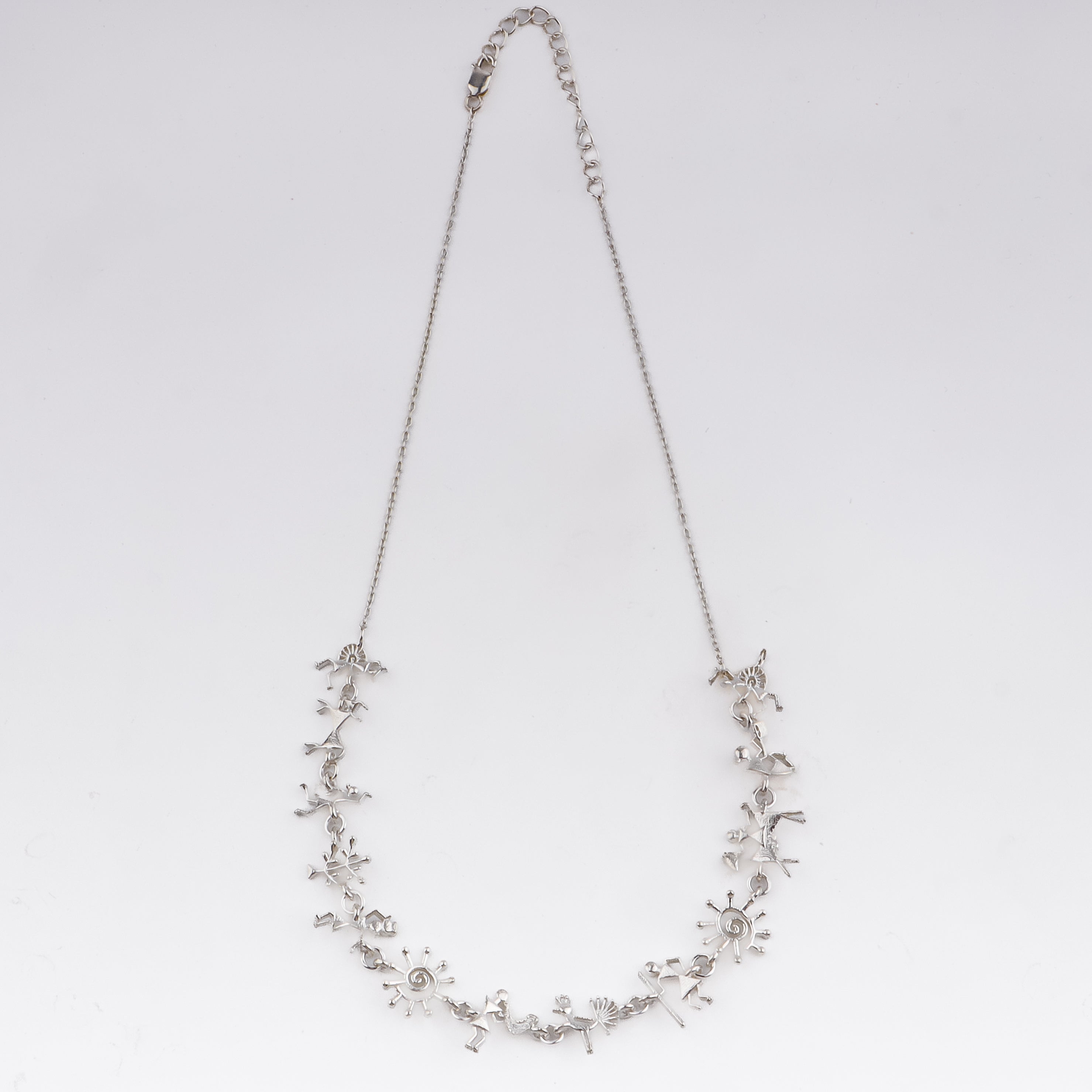 Close-up of silver Warli motif necklace with intricate tribal symbols
