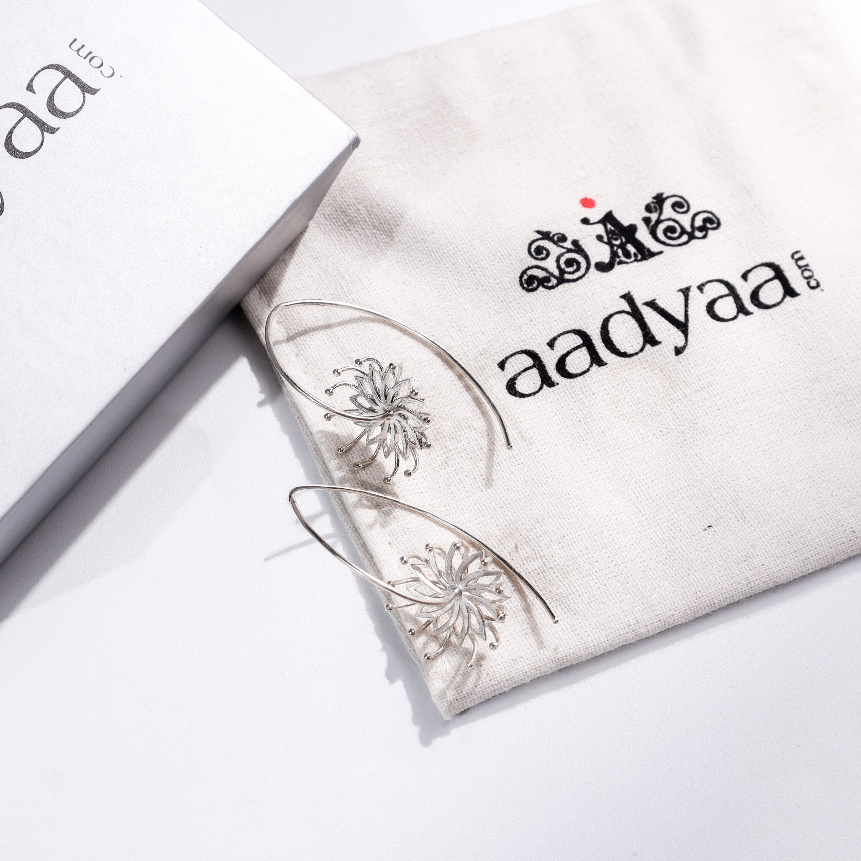 Sterling silver flower earrings with intricate design on Aadyaa jewelry pouch