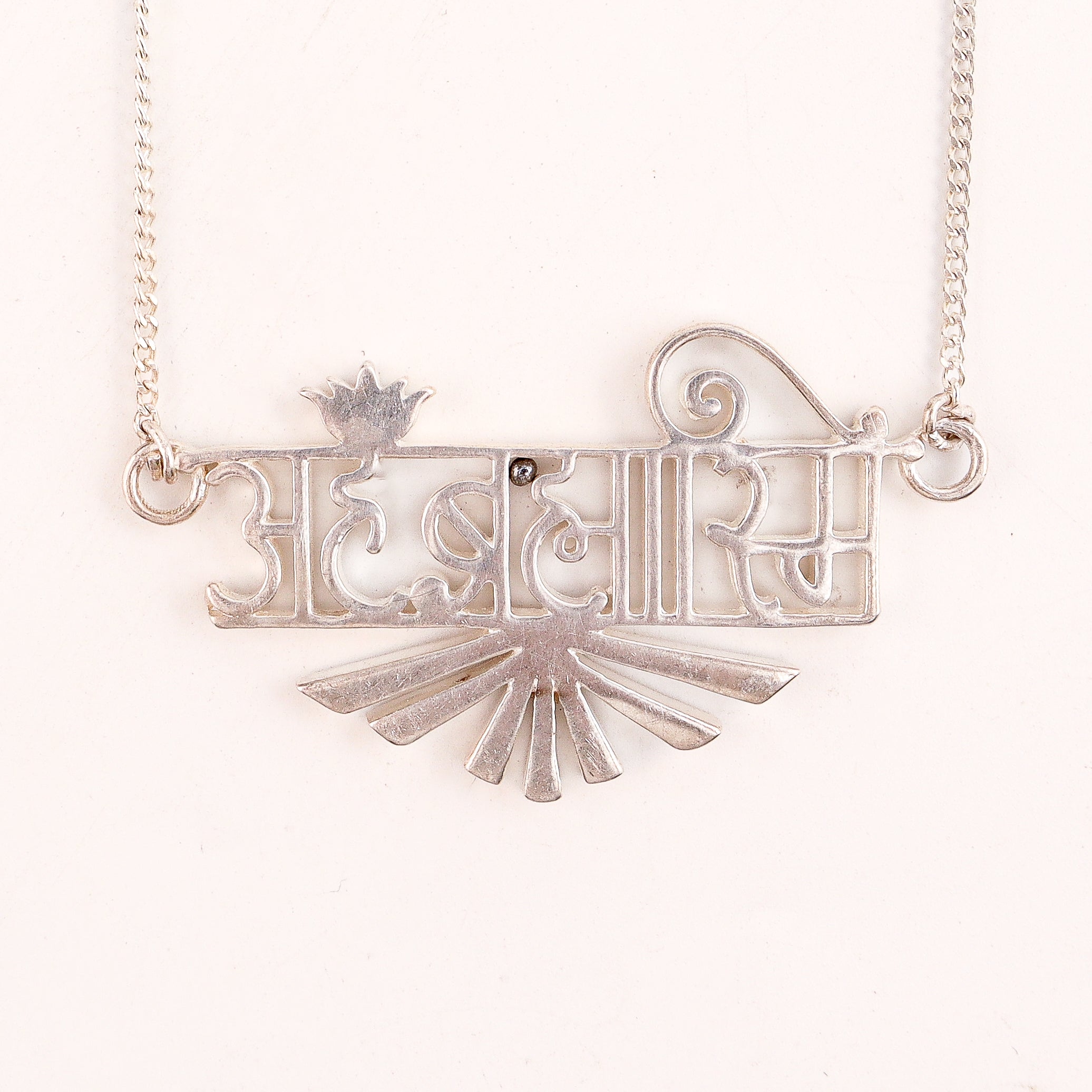 Detail shot highlighting laser cut typography and polished silver finish