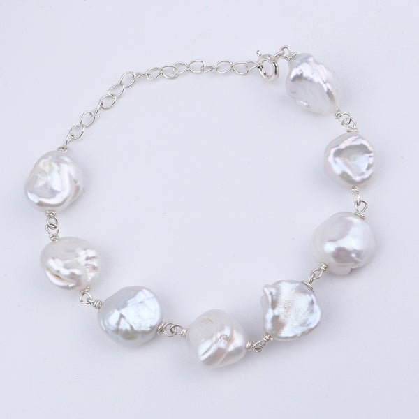 Close-up of white baroque pearls linked with silver chain
