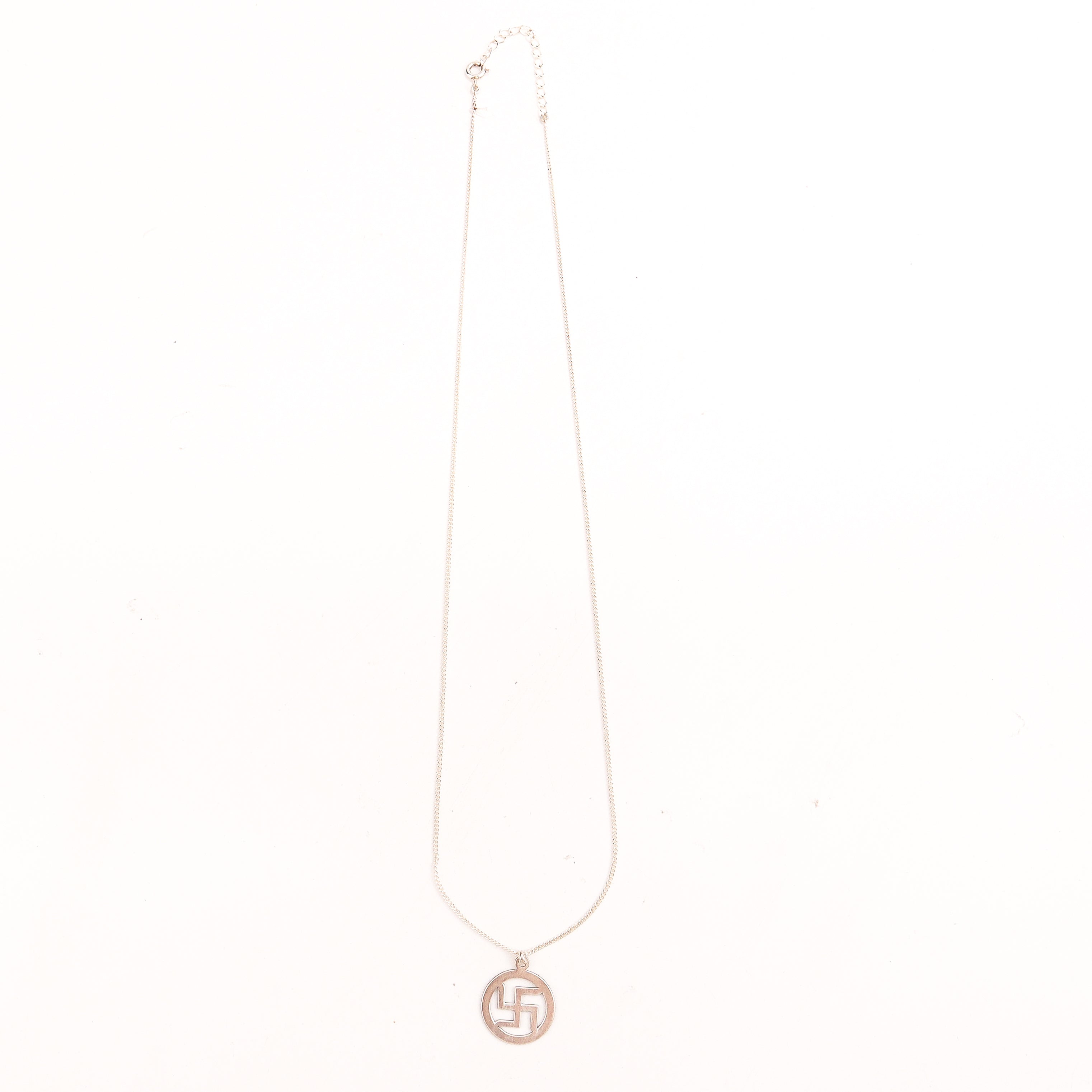 Detail shot highlighting polished silver finish of swastik pendant