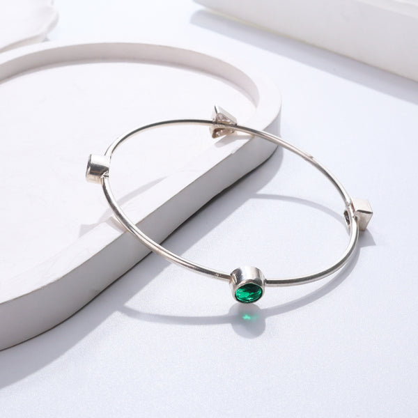 Silver bangle with green gemstone
