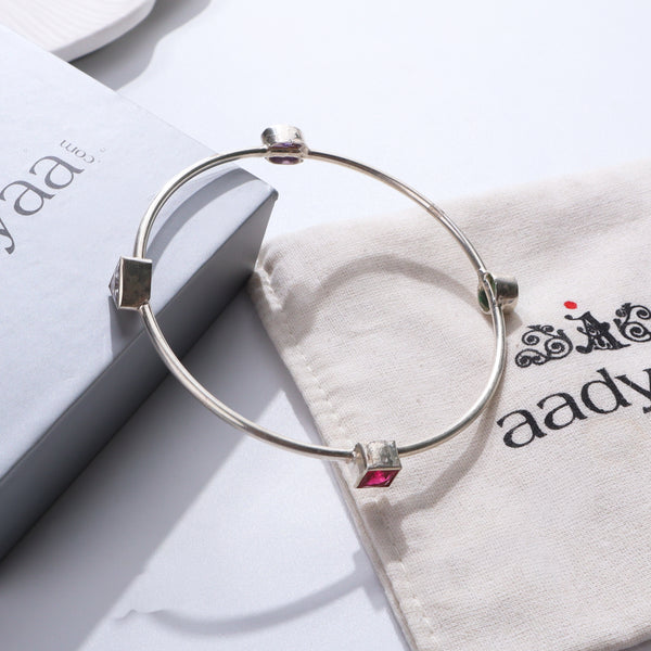 Silver bangle with semi precious stones on white background