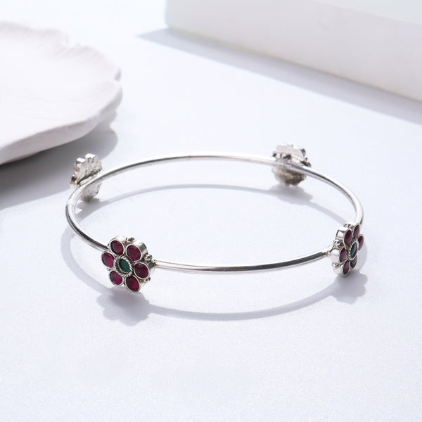Silver bracelet with red and green gemstone accents