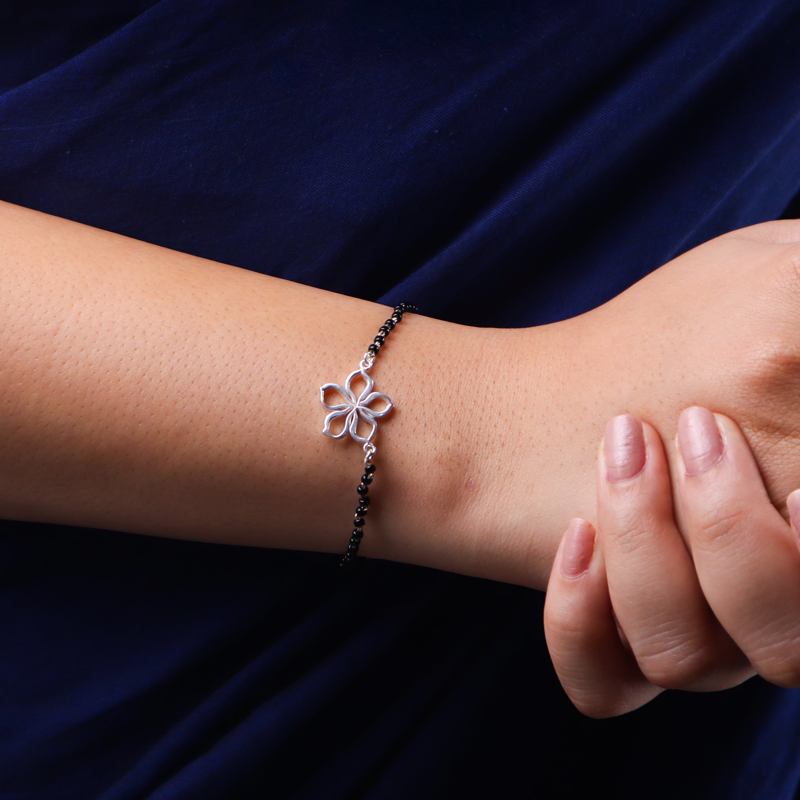 Silver flower-shaped Mangalsutra bracelet on wrist