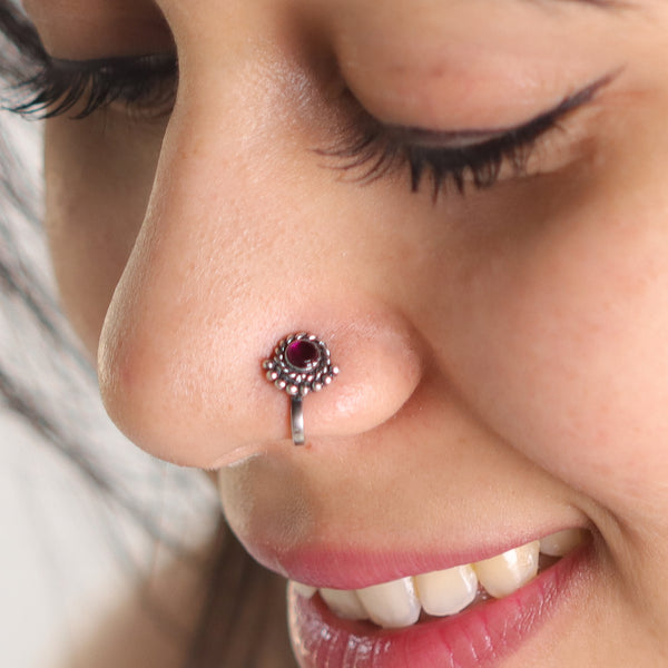 Silver nosepin with red gemstone and intricate design