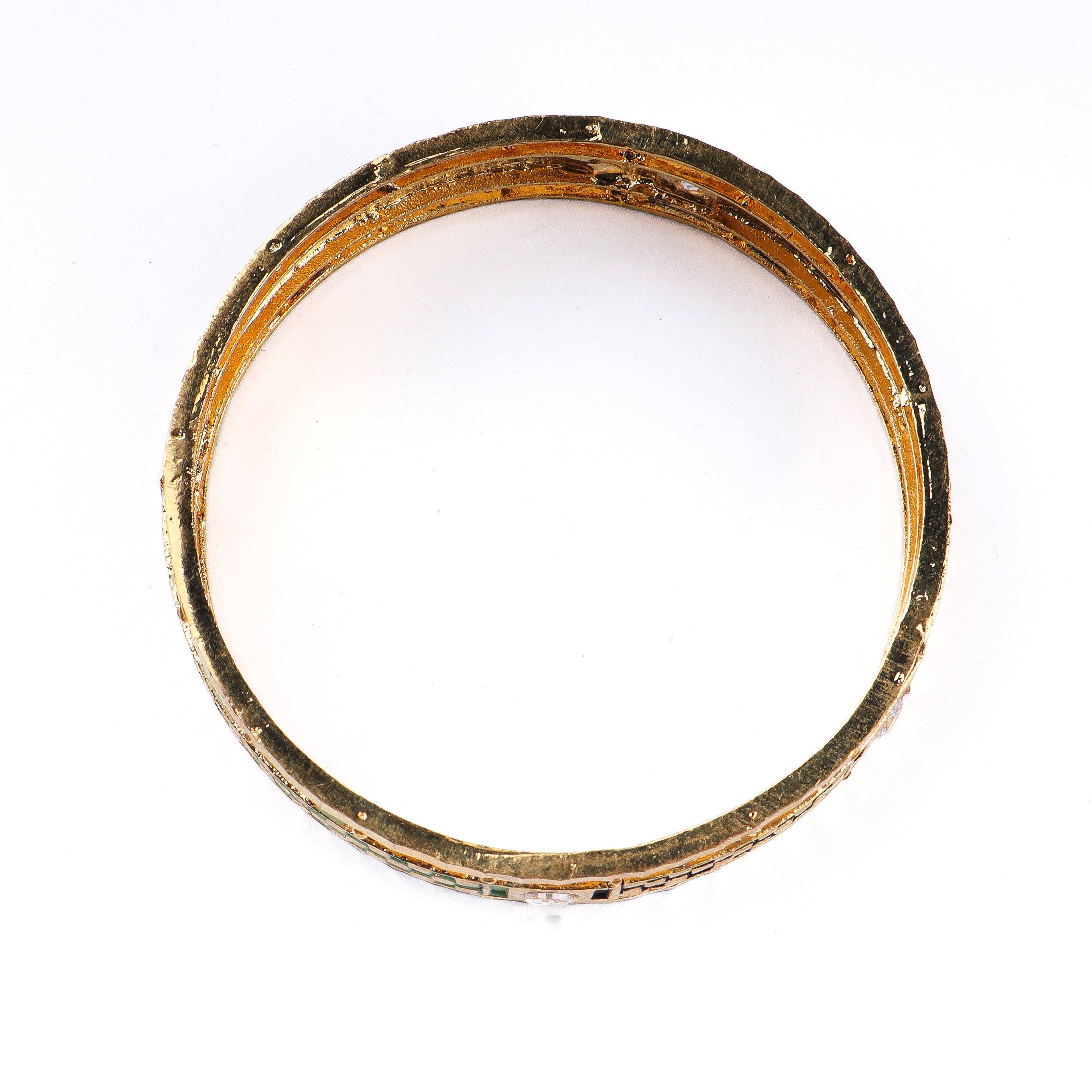 Flat-lay of 22K gold-plated fashion bangle (single) with complementary gold-plated jewelry and elegant accessories
