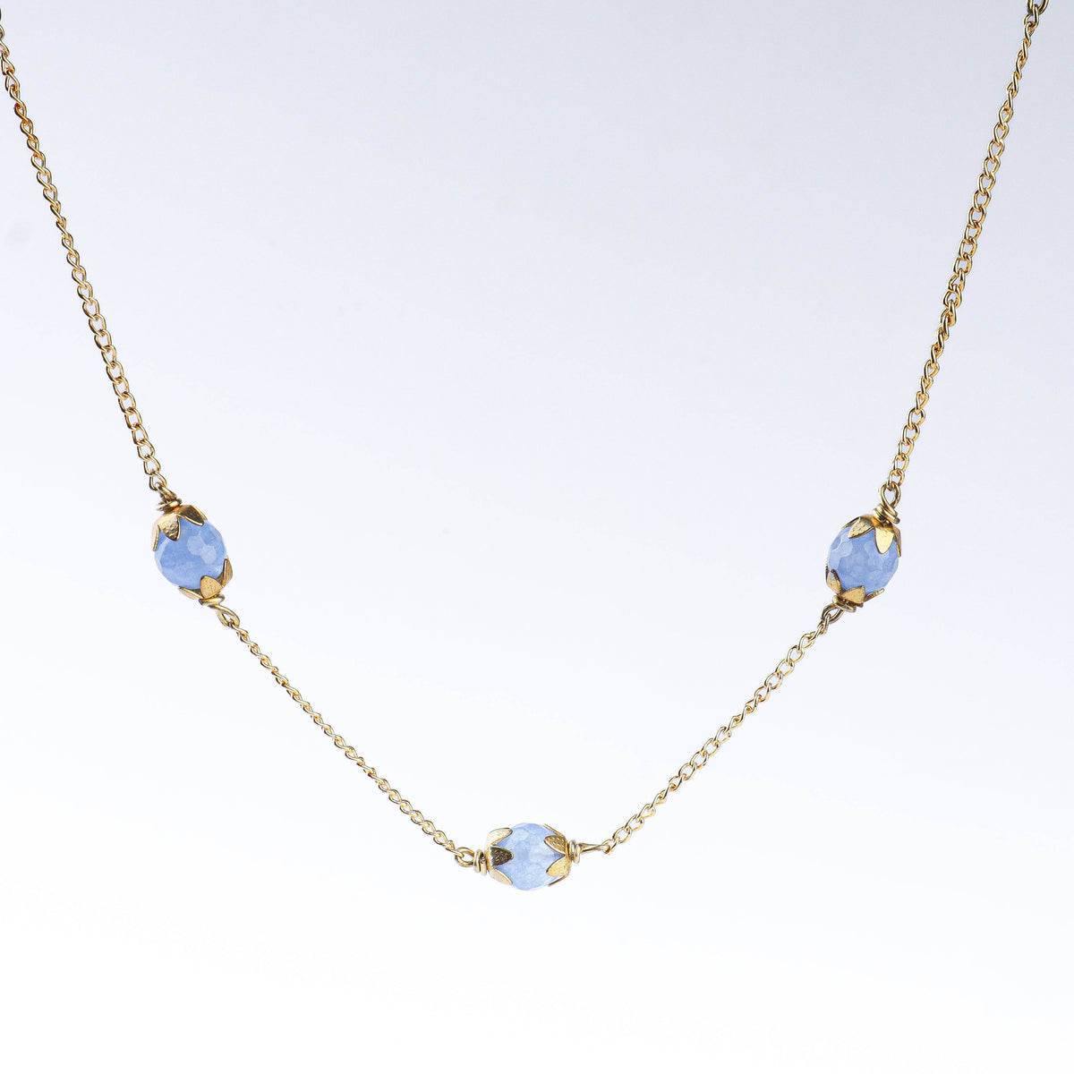Angled view of a 22K gold-plated fashion necklace highlighting its elegant structure, design, and polished gold finish