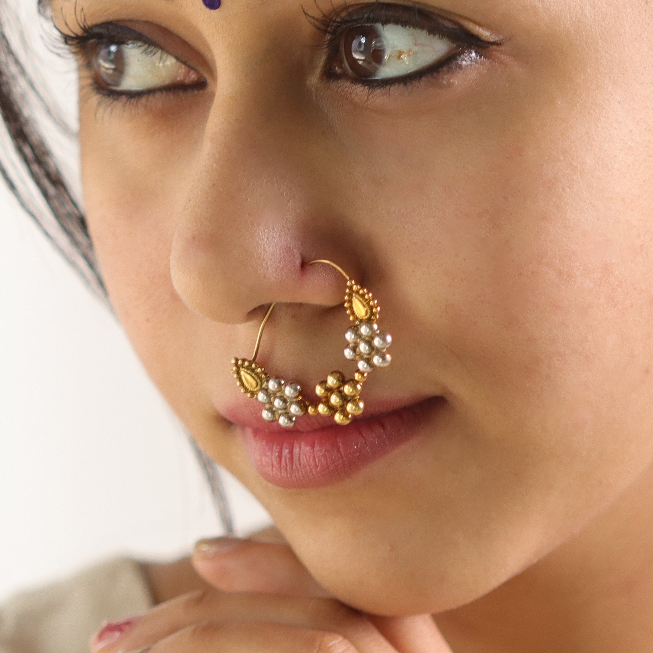 Gold and pearl nose ring with intricate design