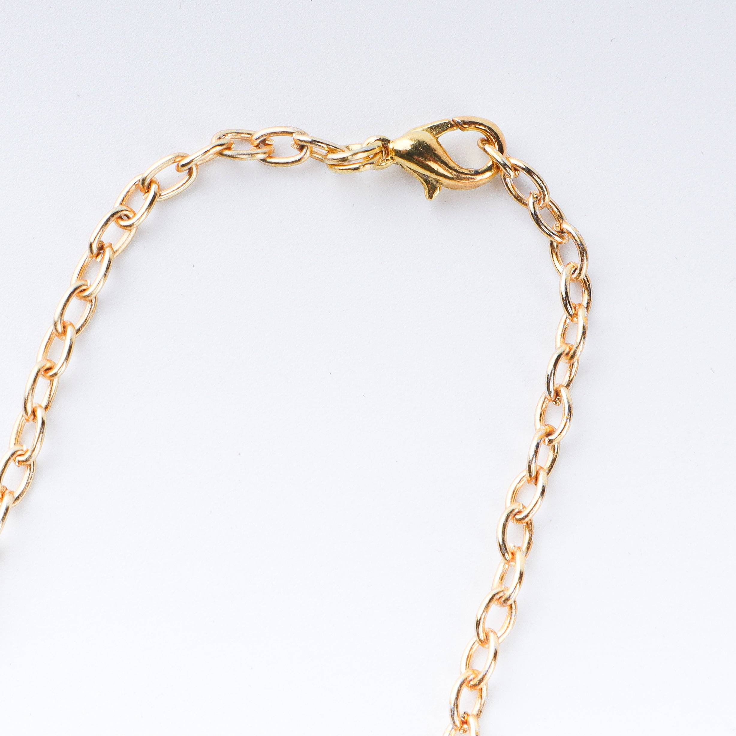 Angled view of a 22K gold-plated fashion necklace highlighting its elegant structure, design, and polished gold finish