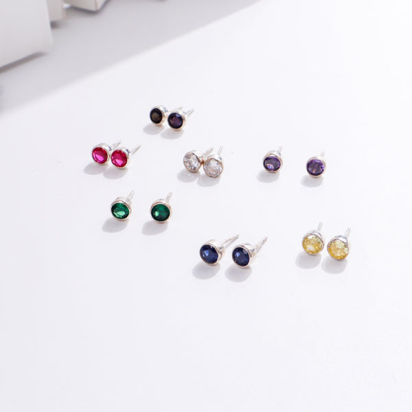 Colorful gemstone stud earrings on white background
