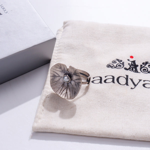 Silver flower brooch on white fabric