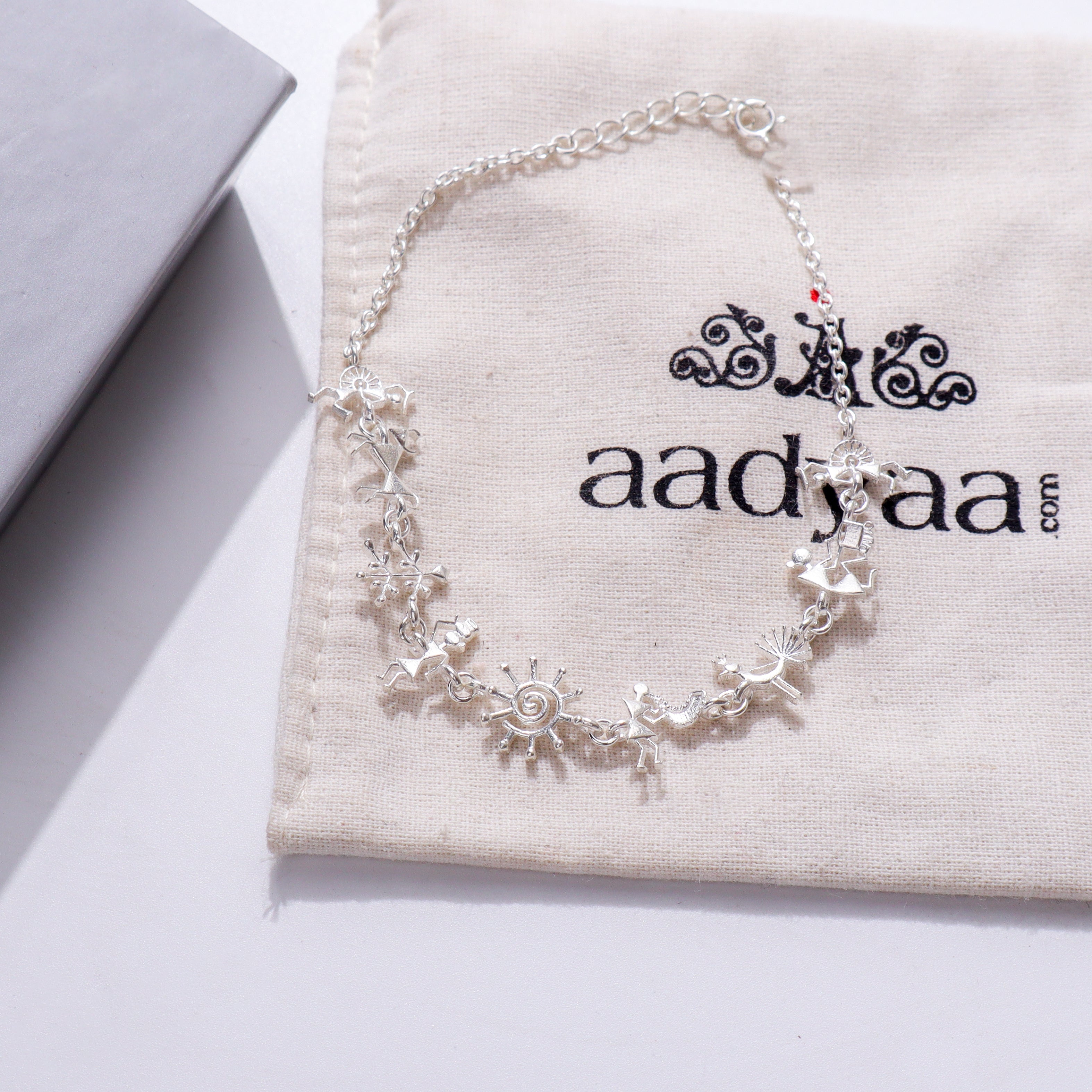 Silver bracelet with Warli motifs on fabric