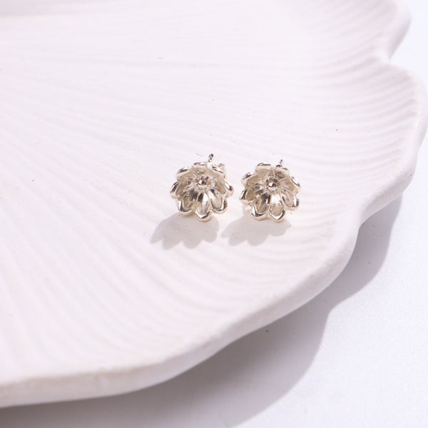 Silver flower stud earrings on white background