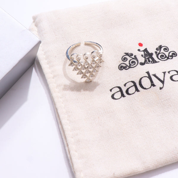Silver Saraswati ring with cubic zirconia on beige fabric