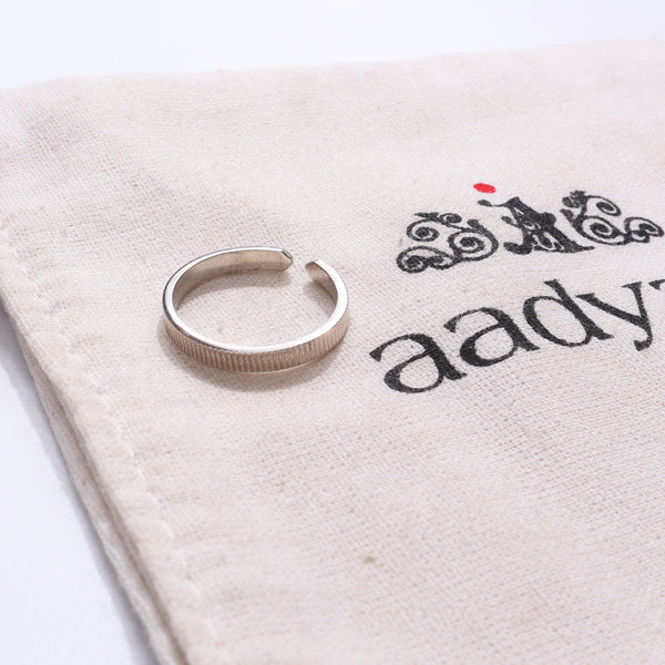 Unisex Silver Ring on beige fabric with black text