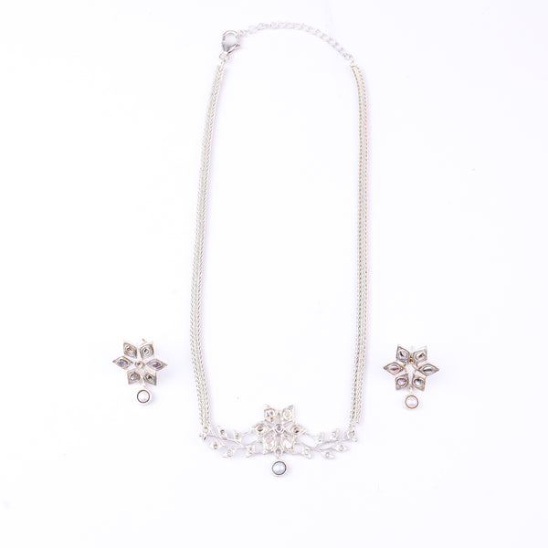 Close-up of silver necklace and earrings with pearl accents