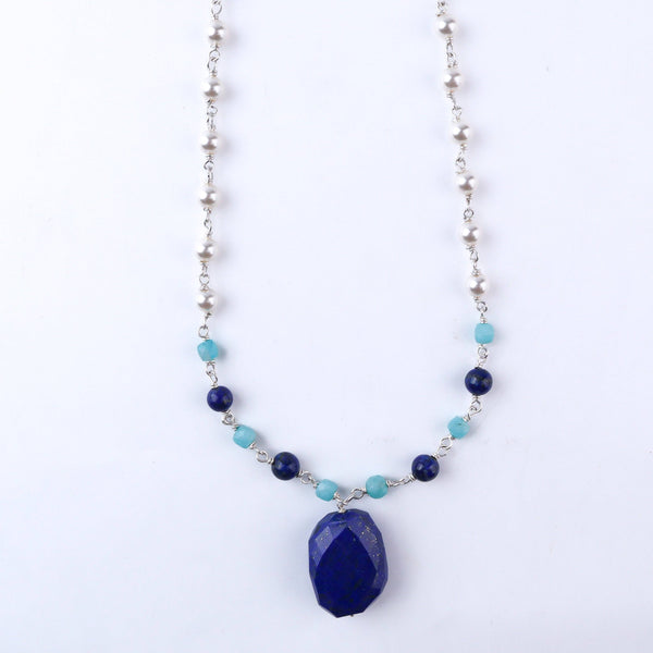 Woman styling 92.5 silver pearl Ganthan necklace with multi-color stones alongside traditional outfit