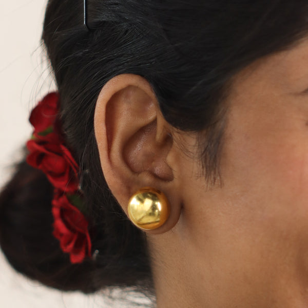 Gold dome earring on woman's ear