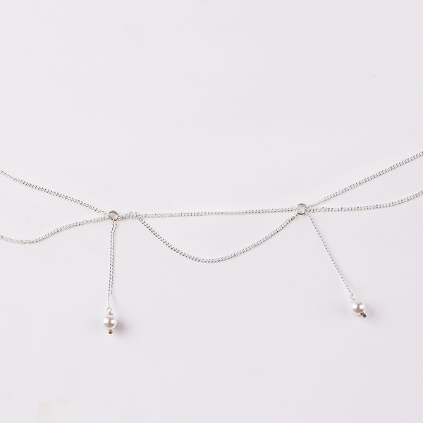 Close-up of silver waist chain with pearl accents and adjustable fit