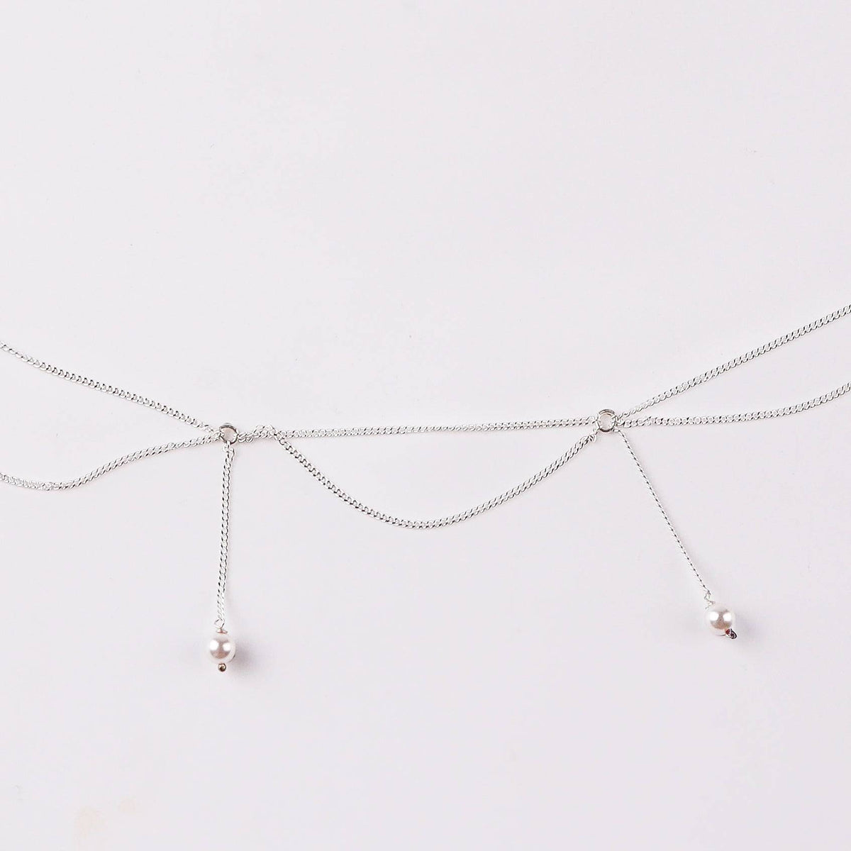 Close-up of silver waist chain with pearl accents and adjustable fit