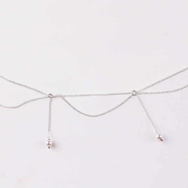 Close-up of silver waist chain with pearl accents and adjustable fit
