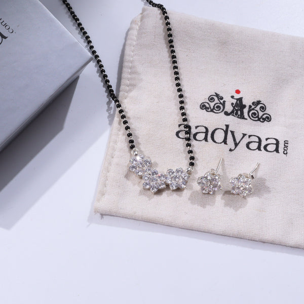 Elegant black beaded necklace with crystal flower pendant on beige fabric