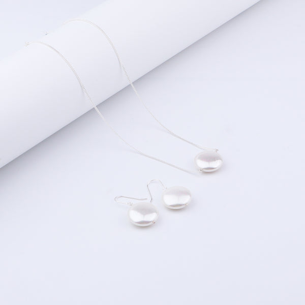 Close-up of pearl necklace and earrings in silver