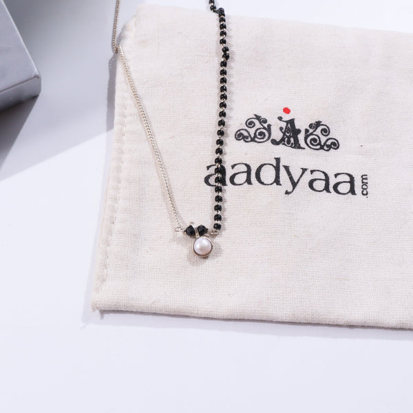 Black and silver pearl drop mangalsutra with pendant on beige fabric