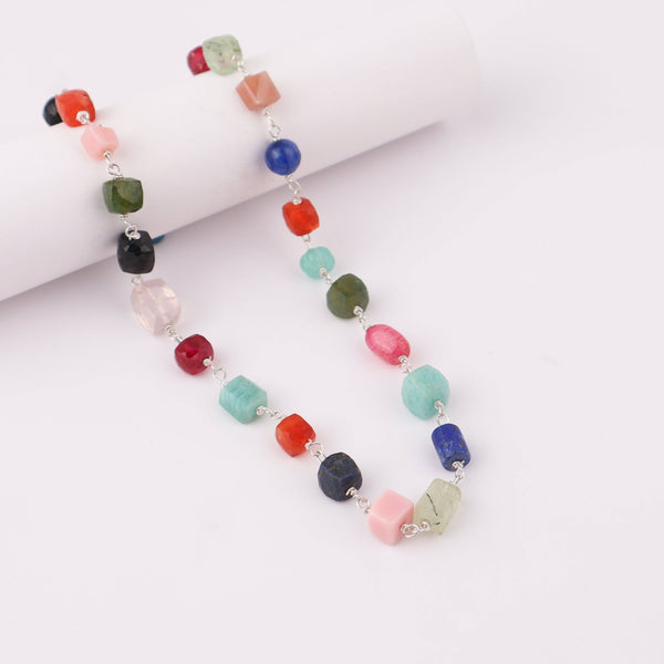 Close-up of gemstone necklace with silver chain, vibrant jewelry piece