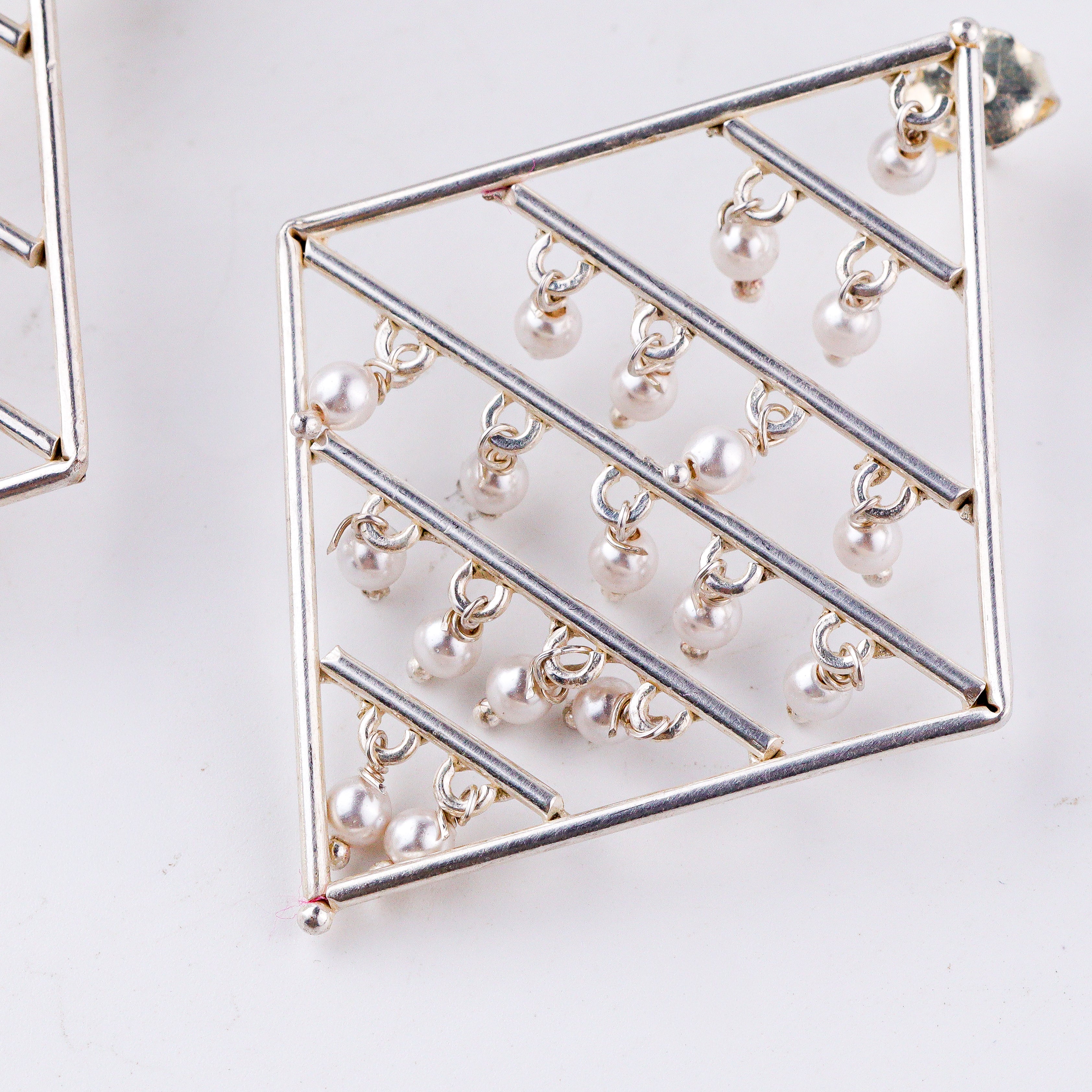 wearing silver geometric pearl earrings statement look