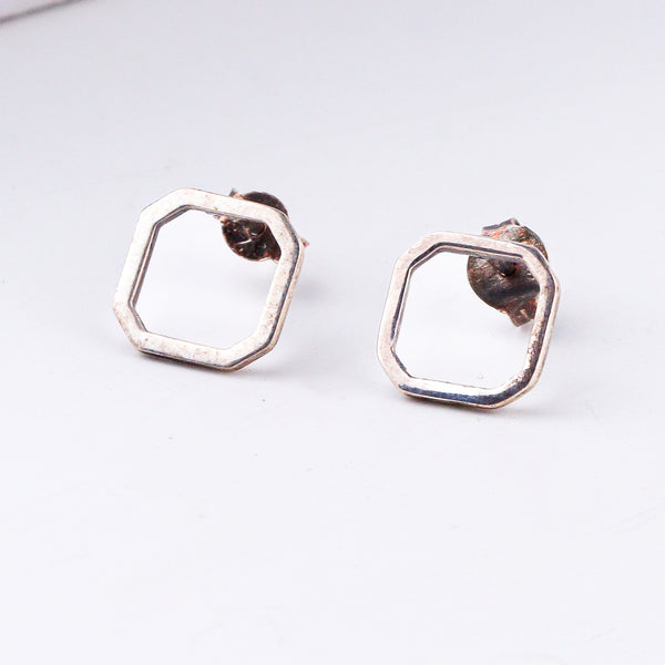 Minimal squircle silver studs close-up handcrafted detailing