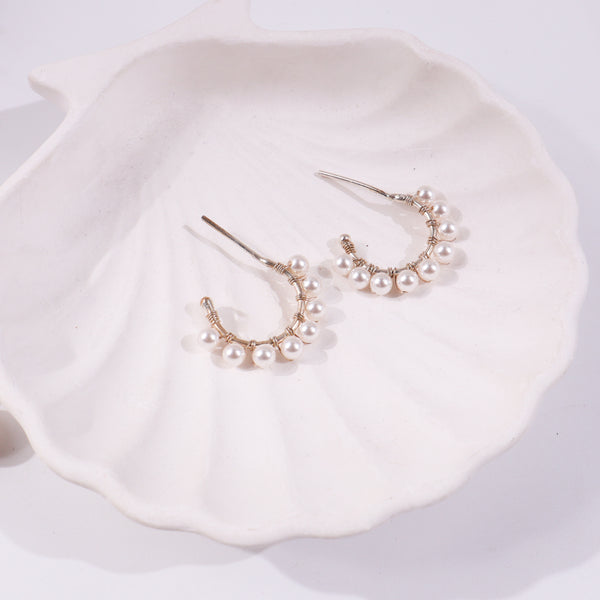 Pearl earrings on white ceramic dish