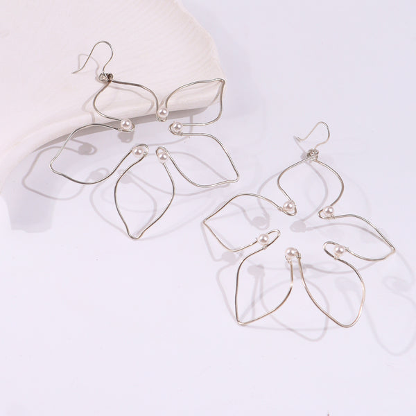 Silver wire earrings with pearl accents on white background