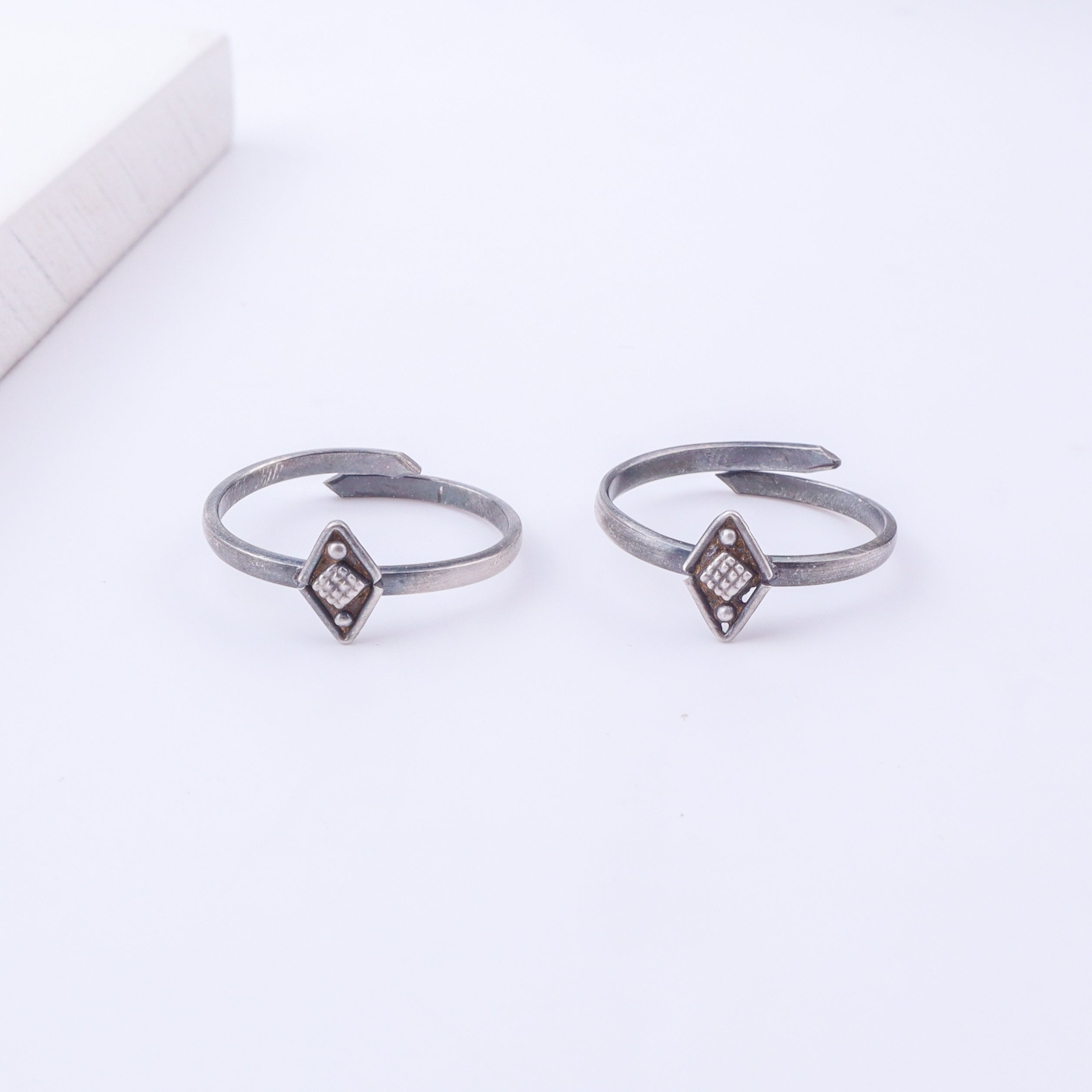 Model wearing tiny silver adjustable textured diamond toe ring