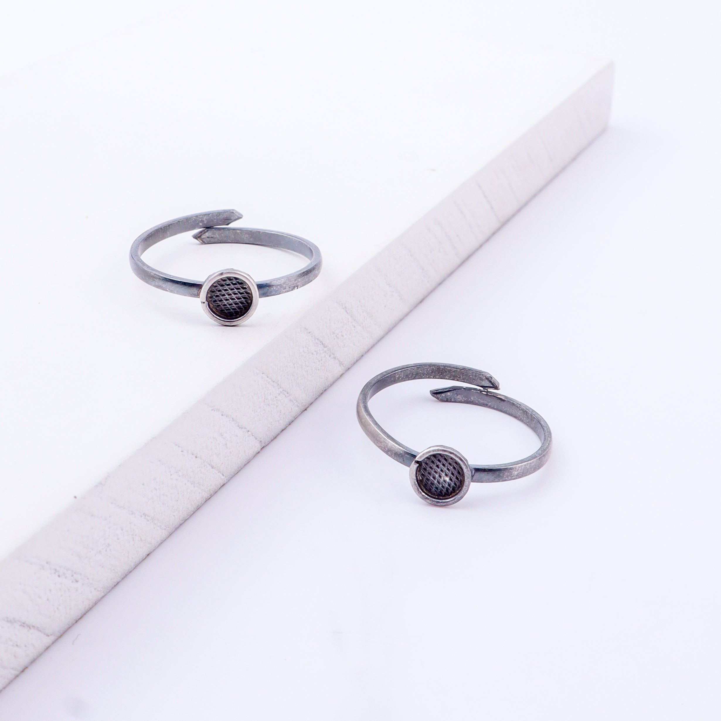Angled view of tiny textured circle silver toe ring adjustable
