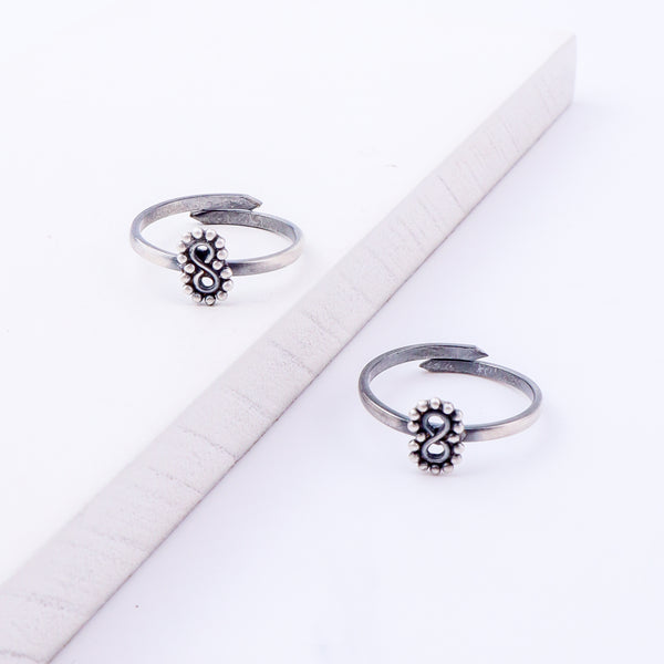 Angled view of tiny infinity silver toe ring adjustable