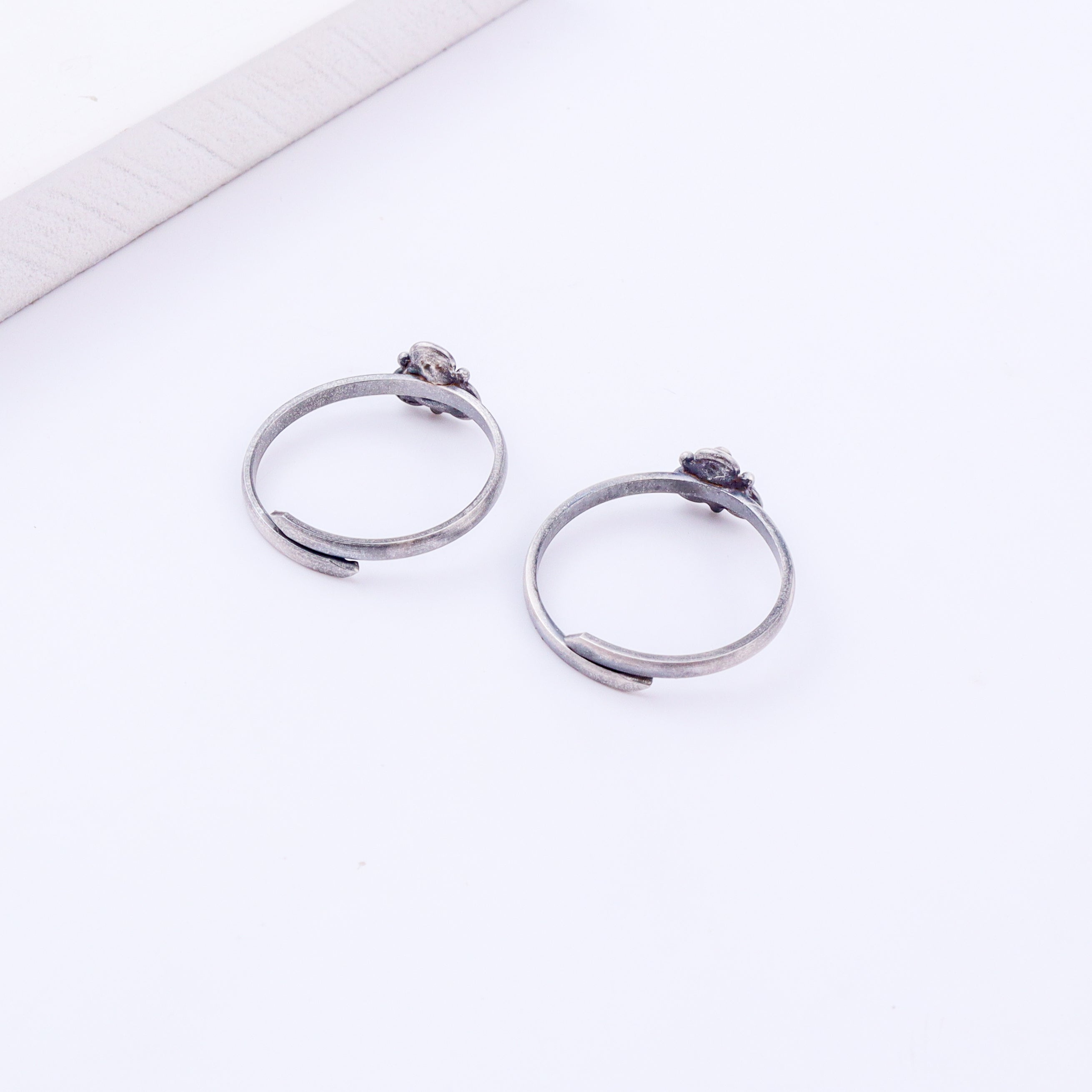 Angled view of tiny silver Trillium adjustable toe ring