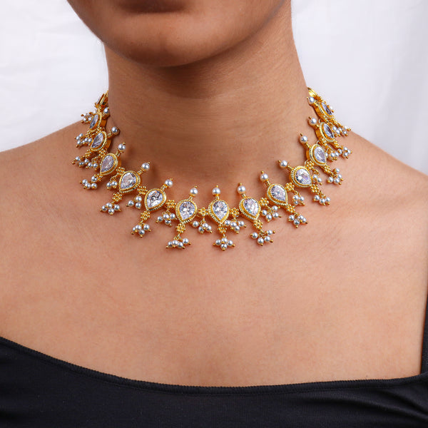 Close-up of a gold and pearl necklace on a woman's neck