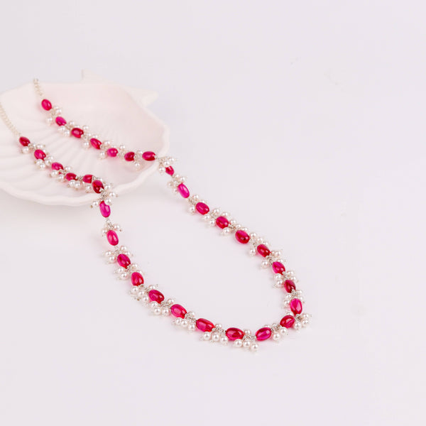 Pink and white pearl and ruby necklace on white background