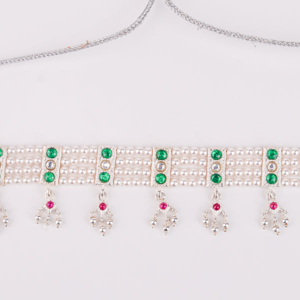 Detail shot of green stone setting and pearl accents