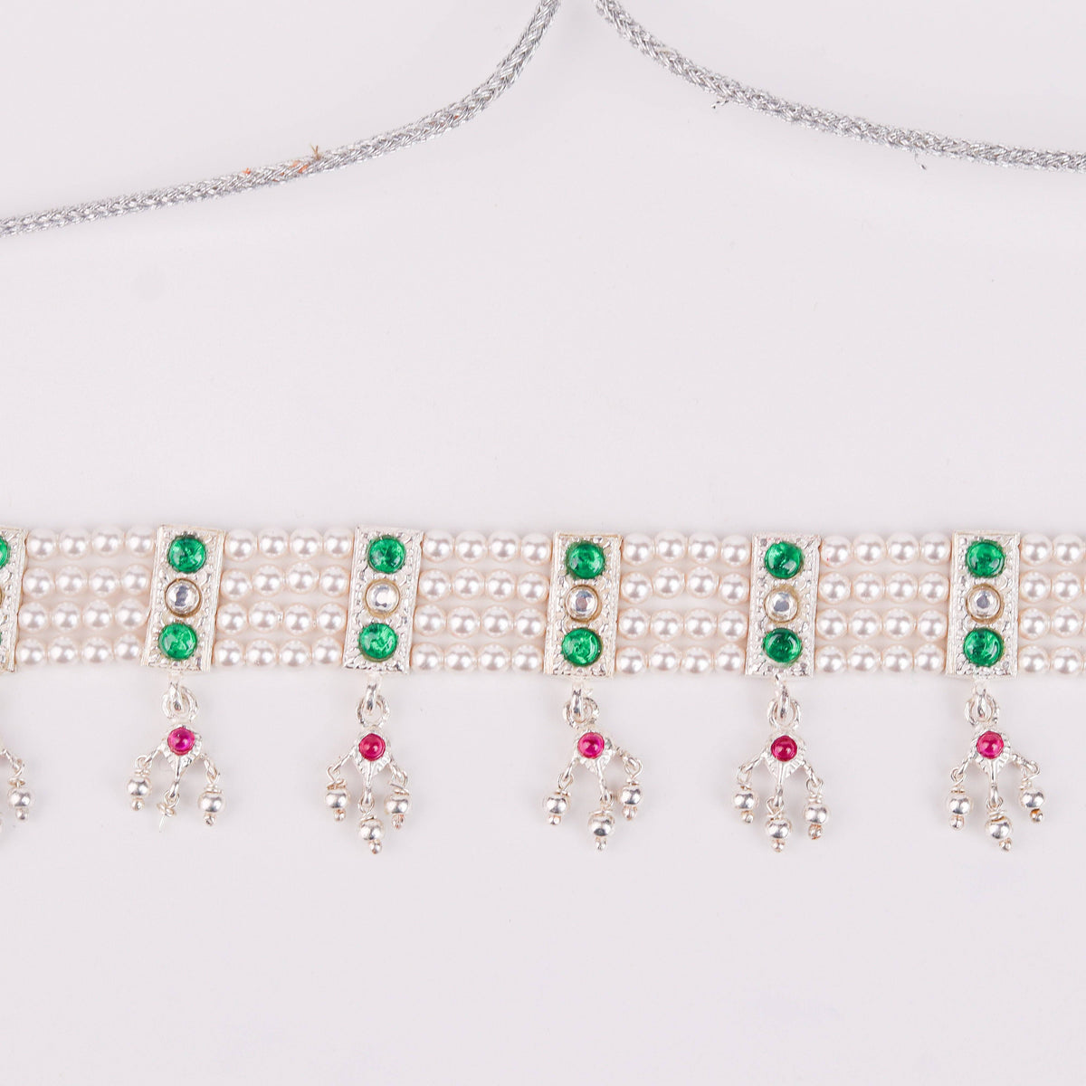 Detail shot of green stone setting and pearl accents