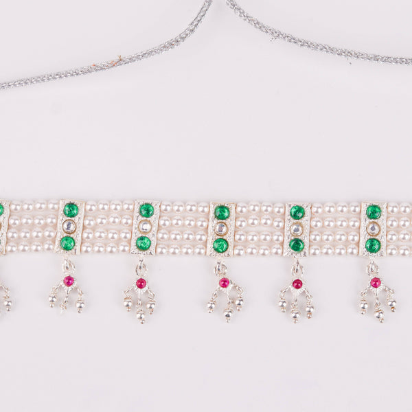 Detail shot of green stone setting and pearl accents
