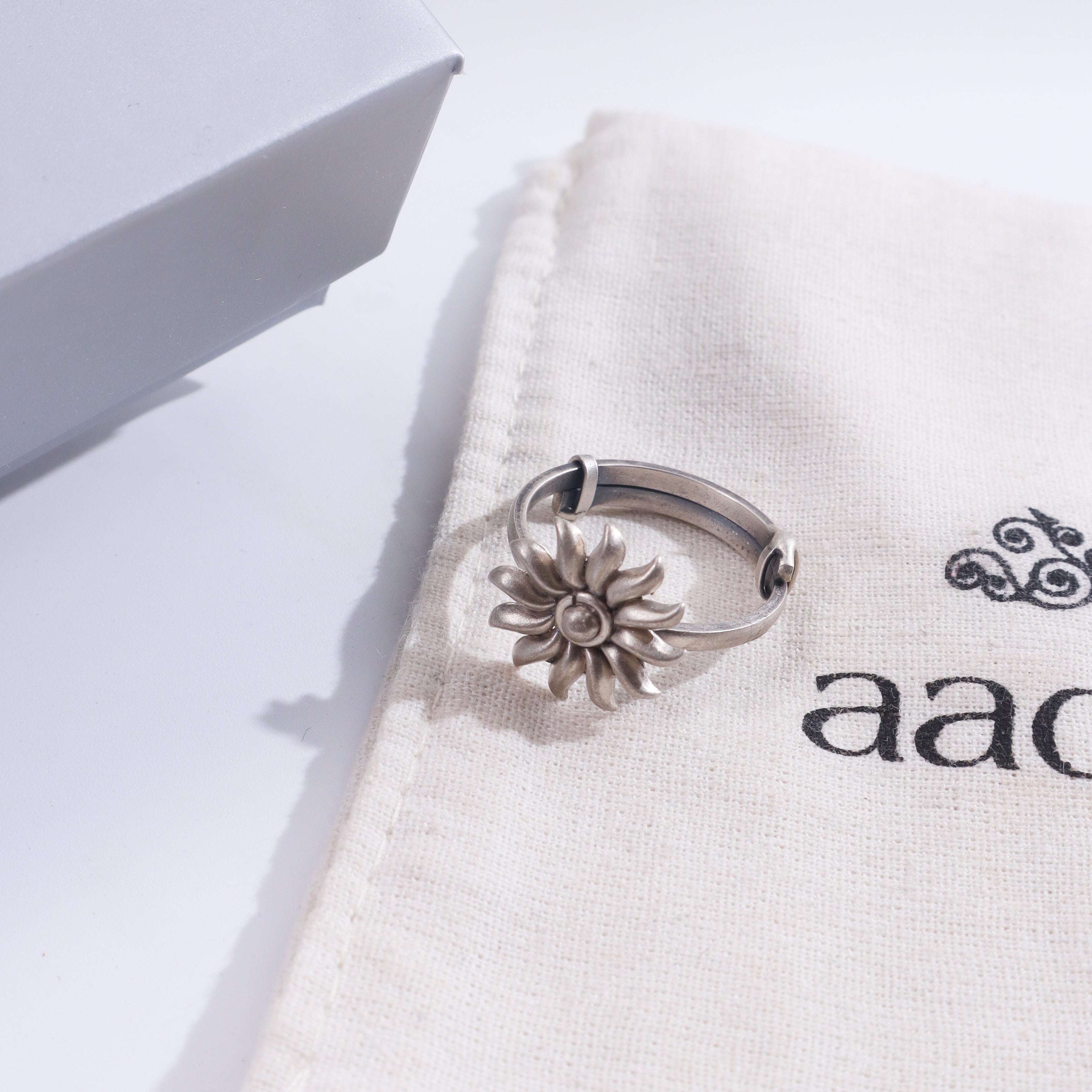 Silver Sun ring on white fabric