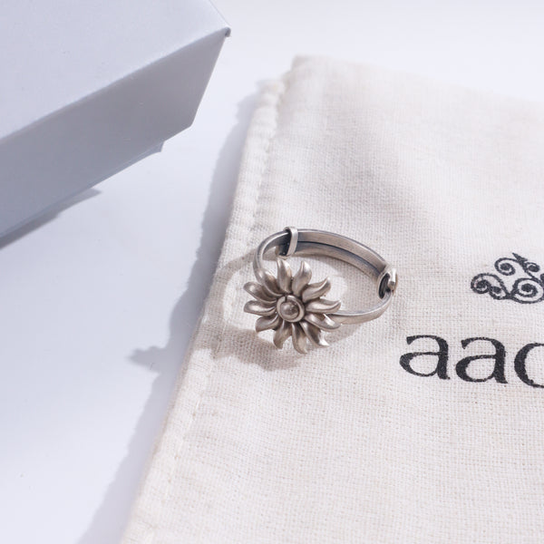 Silver Sun ring on white fabric