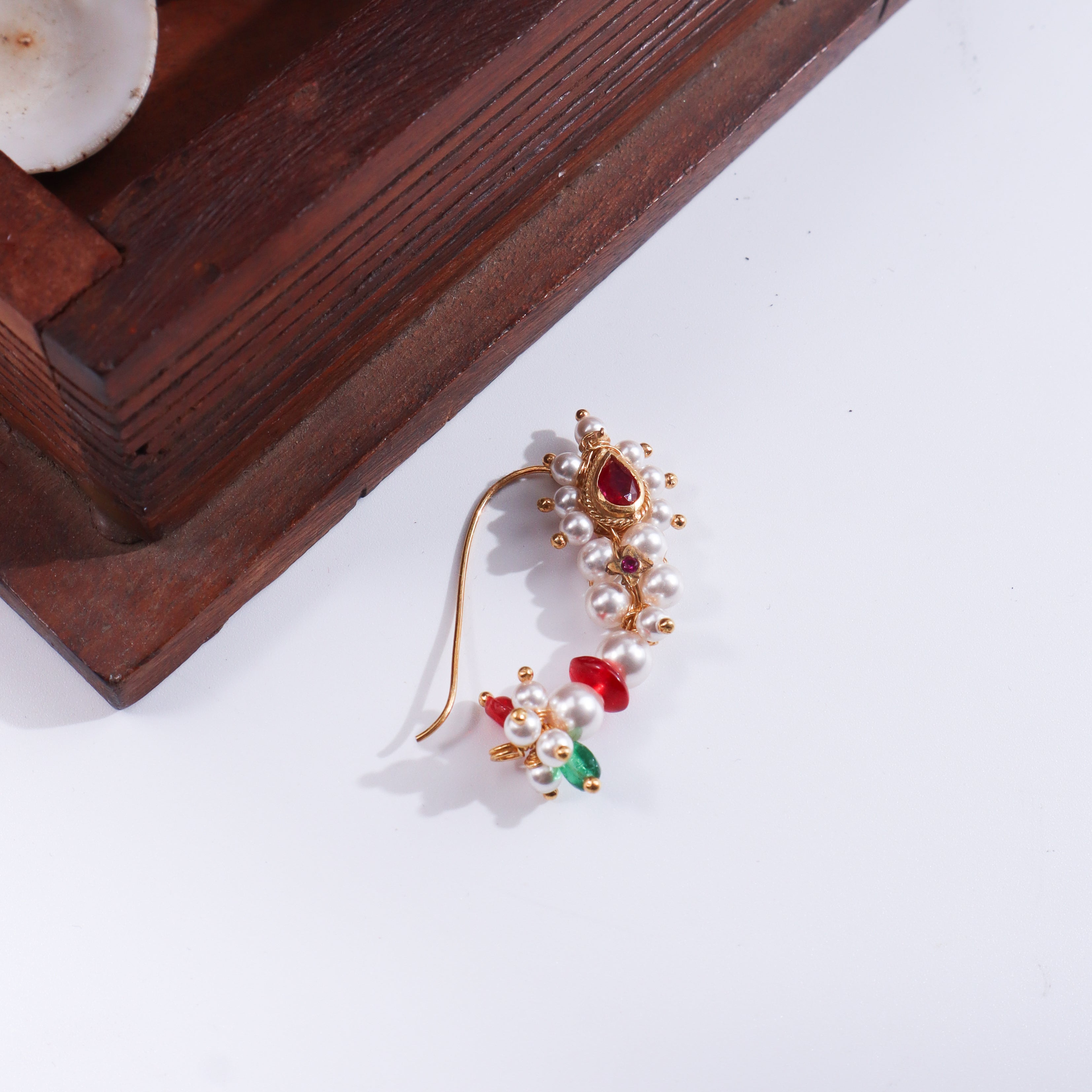 Detailed view of gold-plated pearl and ruby nose ring