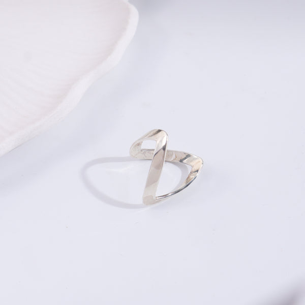 Silver ring with twisted design on white background