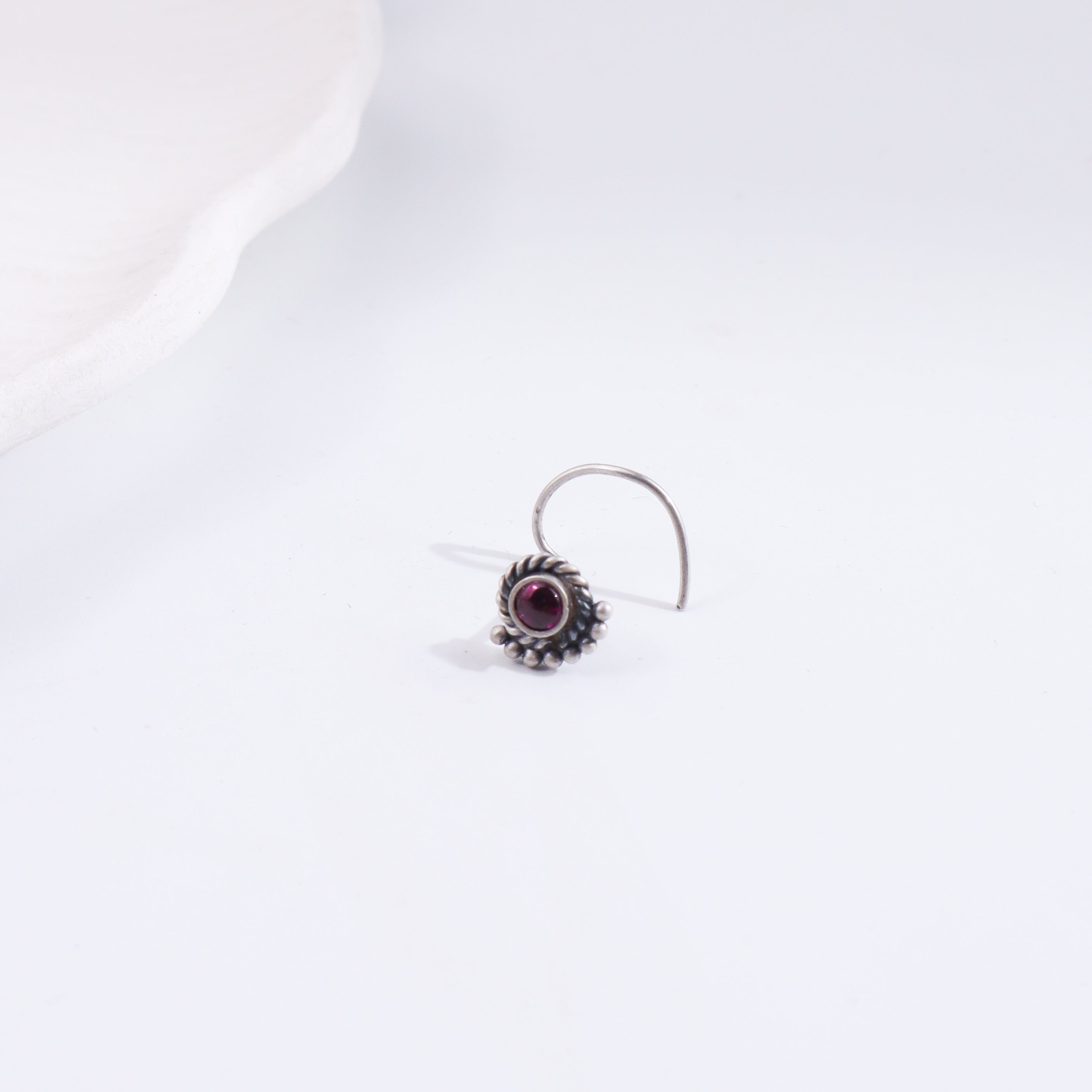 Silver crescent nose pin with purple gemstone
