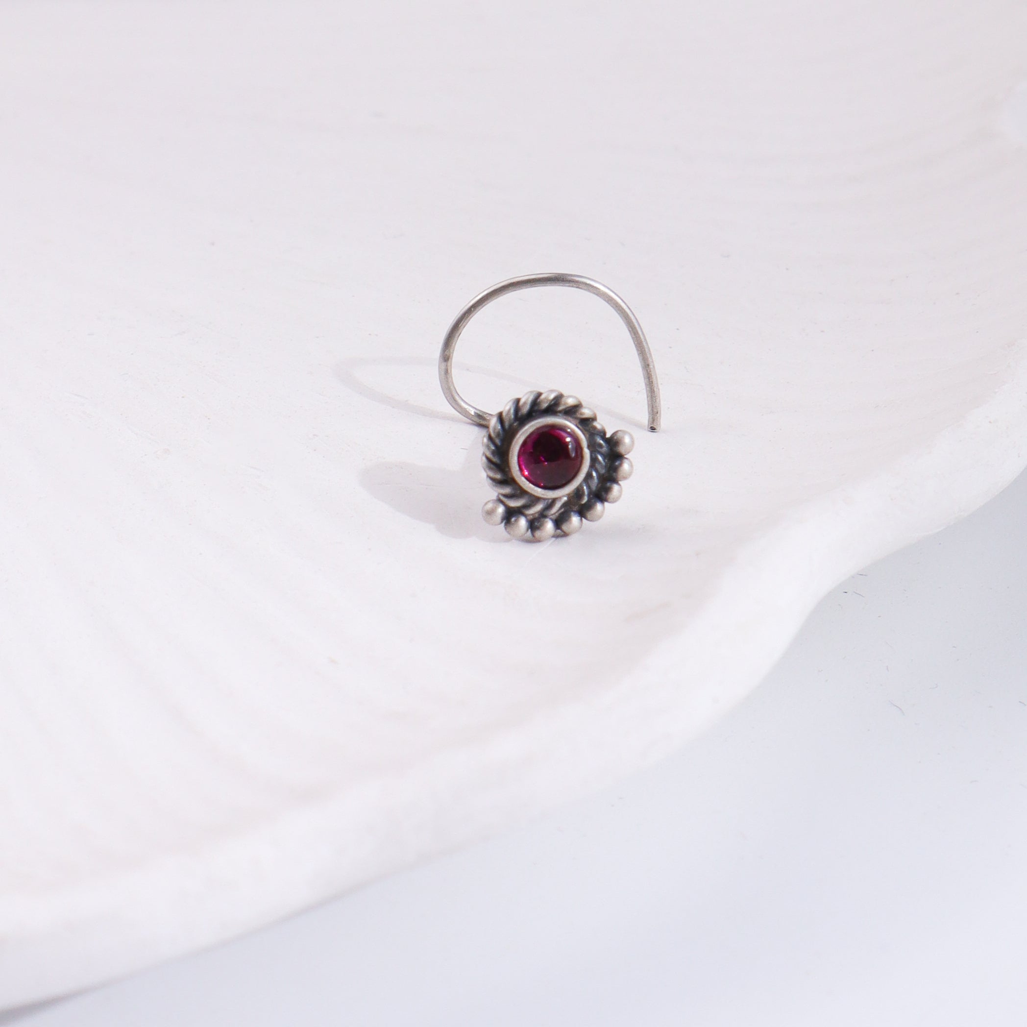 Silver crescent nose pin with pink gemstone