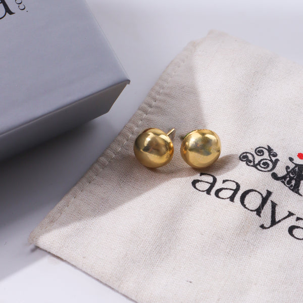 Gold ball earrings on fabric